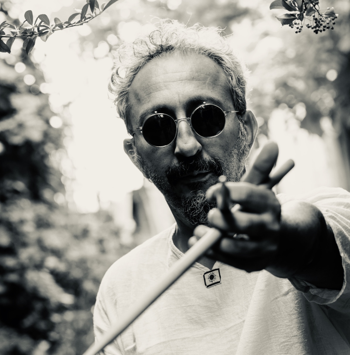 Portrait rapproché du visage de MoAdib Garti pointant une paire de baguette de batteur vers l'avant